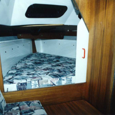 Forward 'V' berth with teak paneling (photo courtesy of General Boats)